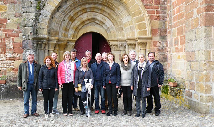 Groupe de chanteurs devant l'église romane du 12e à Agonges, Allier, Auvergne